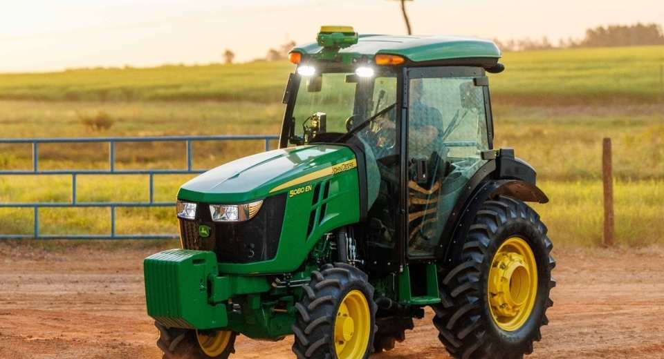 Tractor John Deere Serie 5000 de diseño compacto operando en terreno agrícola, modelo distribuido por Salfa para pequeños y medianos productores.
