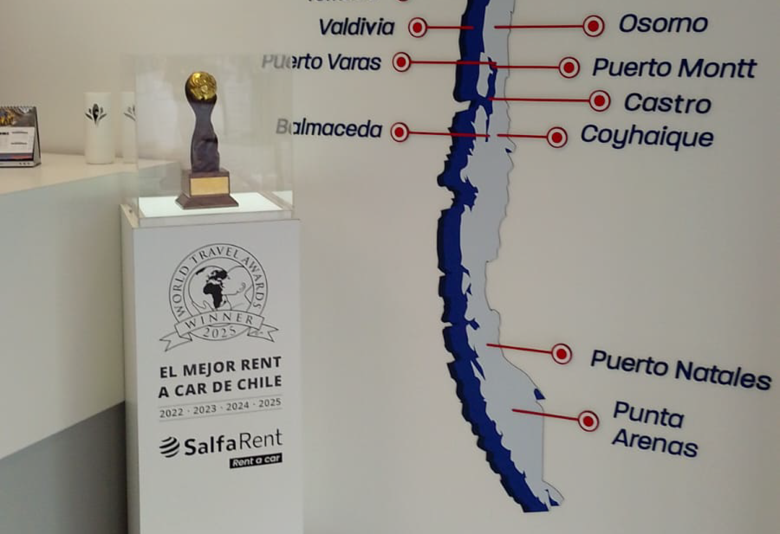 Trofeo World Travel Awards 2025 que reconoce a Salfa Rent como el Mejor Rent a Car de Chile, exhibido junto al mapa de cobertura nacional.
